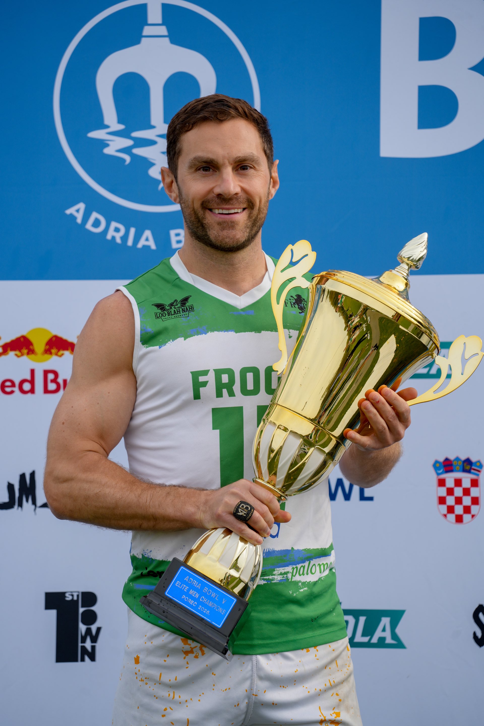 Ein Spieler der Ljubljana Frogs mit der Adria-Bowl-Siegertrophäe