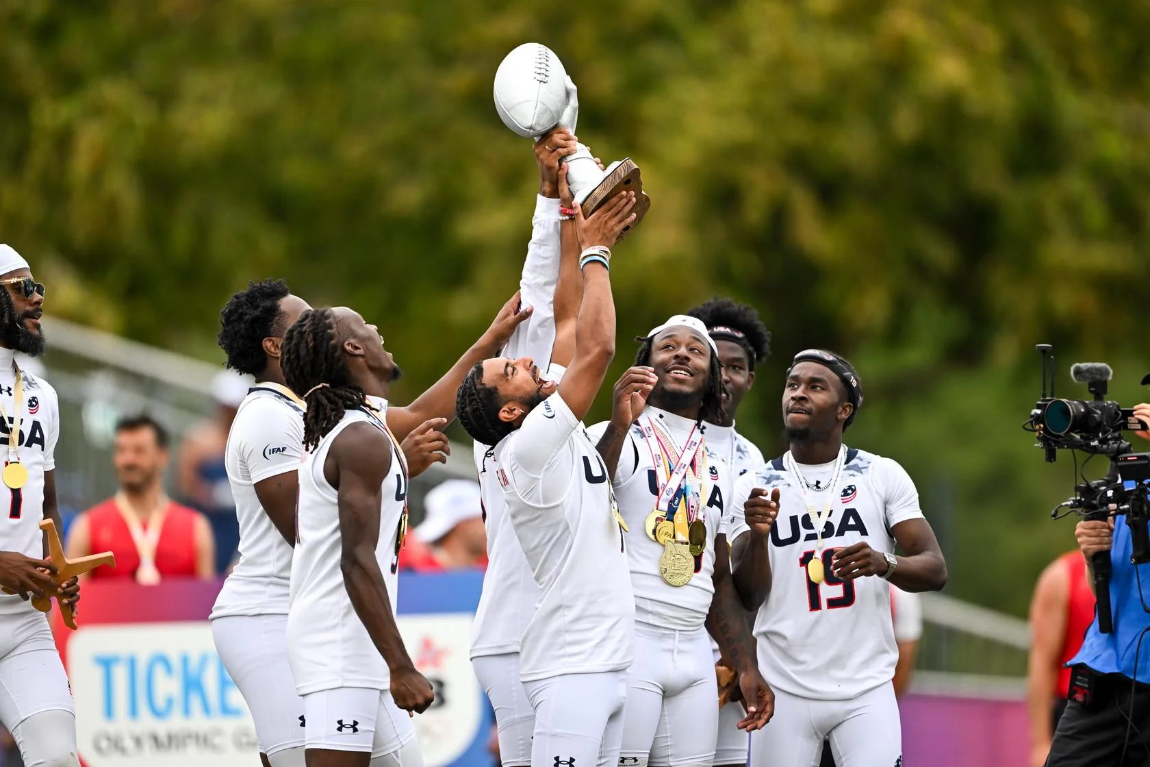 Giocatori di flag football festeggiano con il trofeo dopo i WC26